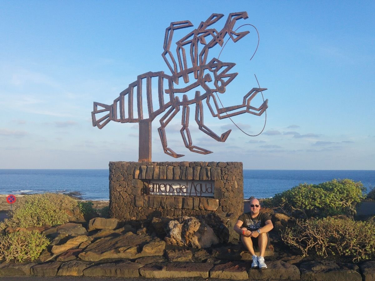 ntrada a los Jameos del Agua, Lanzarote, con cielo despejado y turistas con ropa veraniega, ideal para ilustrar el clima cálido de la isla.
