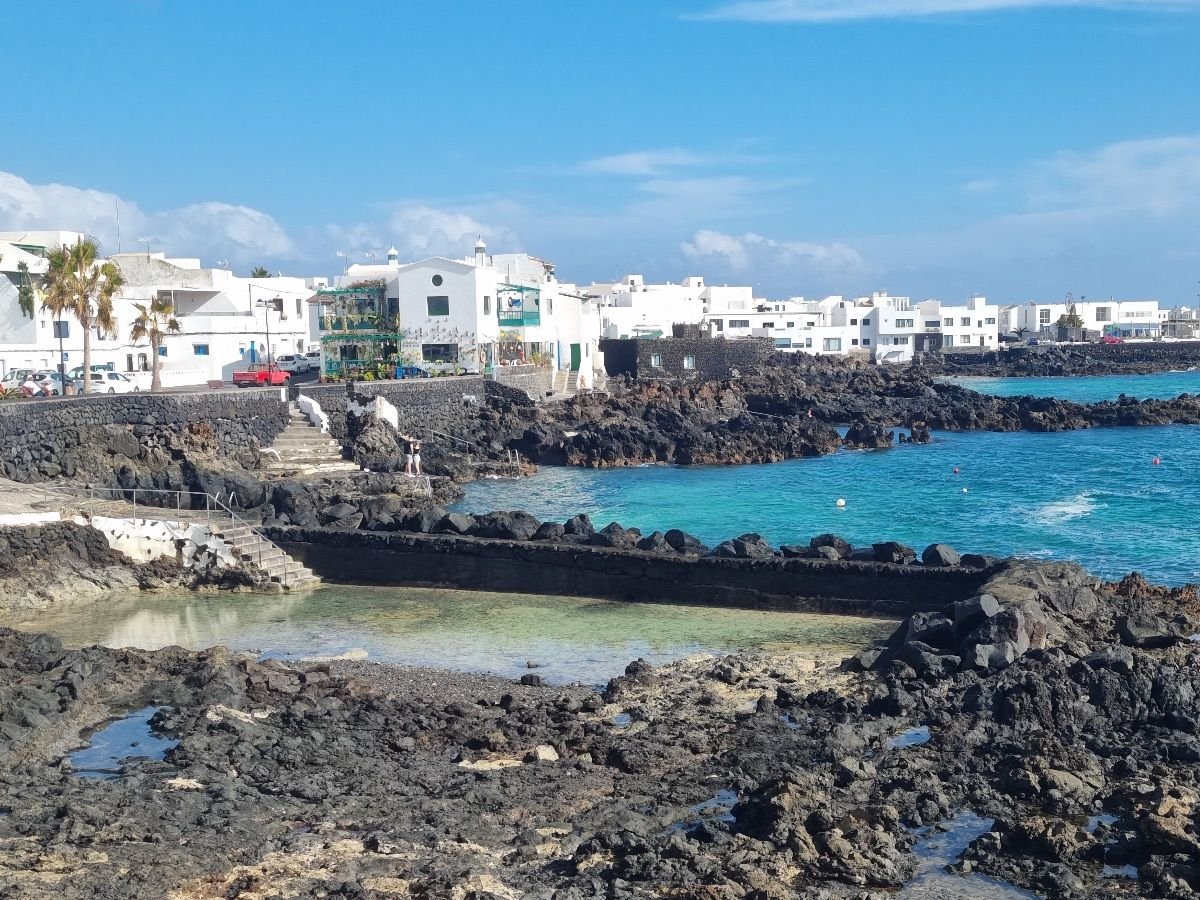 Piscinas naturales de Punta Mujeres con aguas cristalinas y casas blancas junto al mar en el norte de Lanzarote