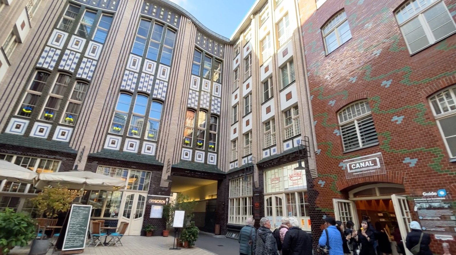 Entrada a los patios del Barrio Judío de Berlín, como Hackesche Höfe, con arte urbano y tiendas locales.