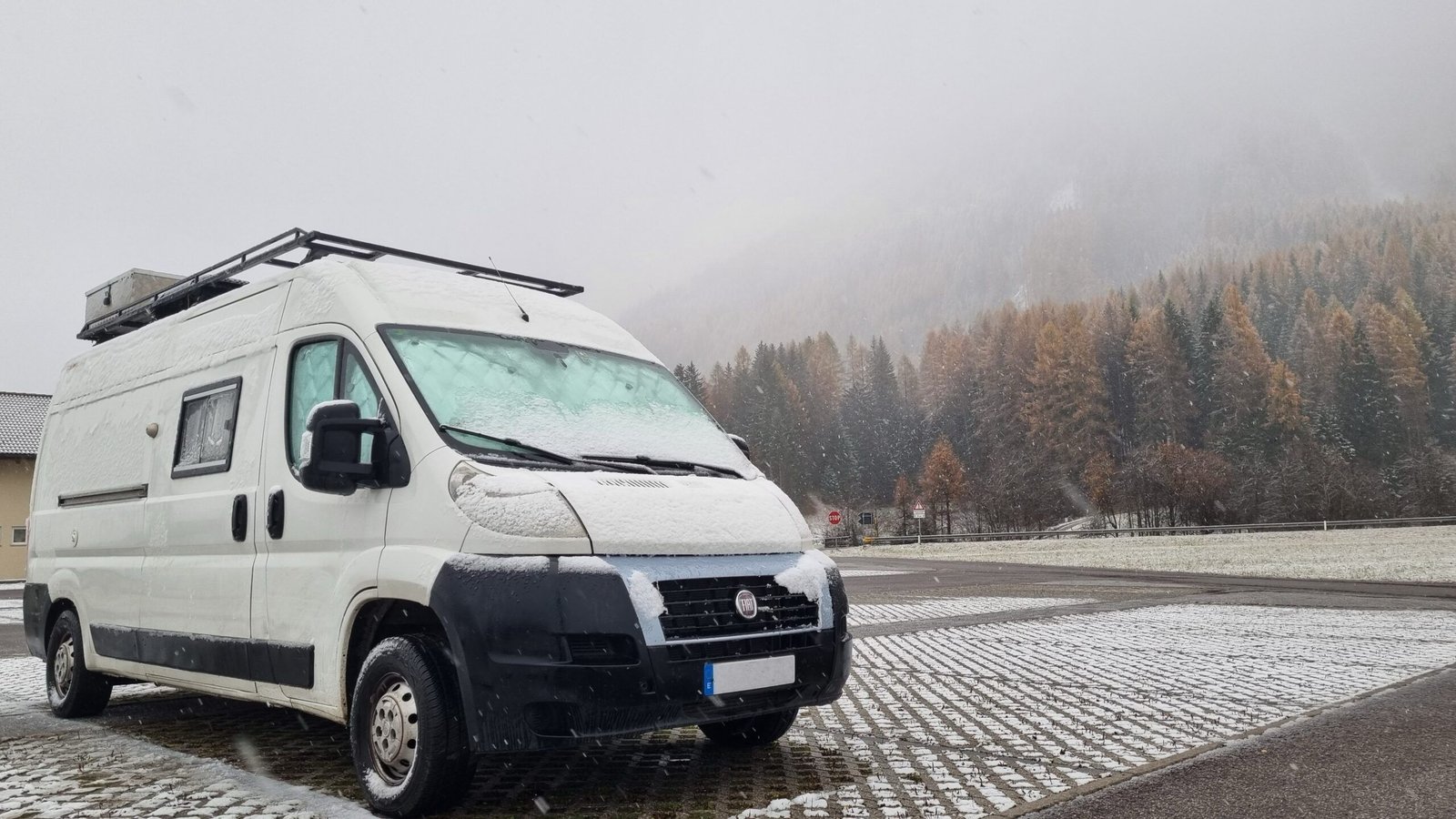 Camper cubierta de nieve durante un viaje de invierno por carretera